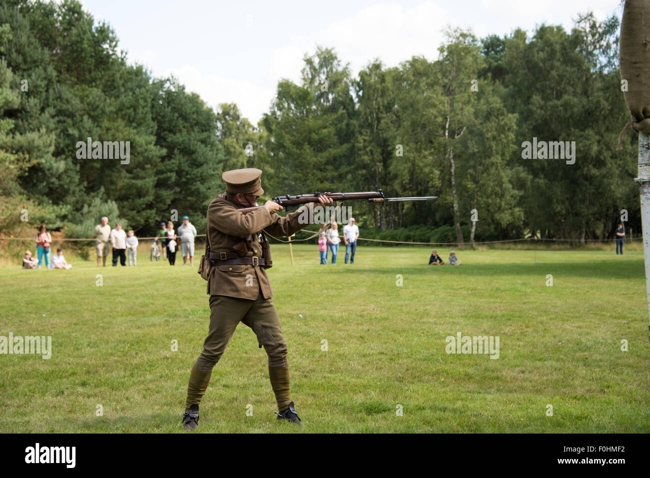 Reconstitution de WW1 soldat tirant son arme lors d'un affichage à Cannock Chase Visitor Centre UK Banque D'Images