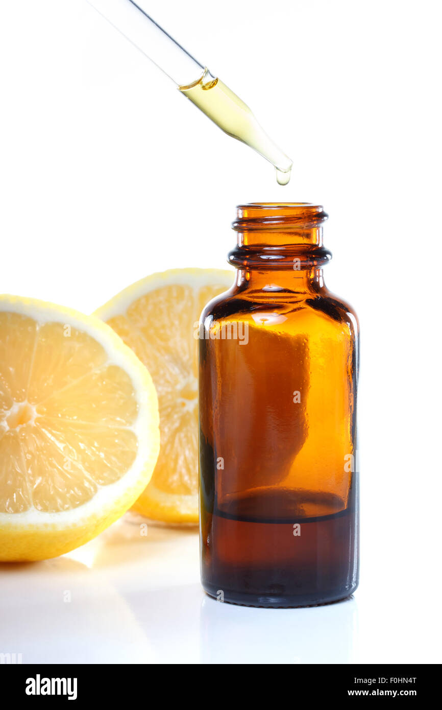 Phytothérapie flacon compte-gouttes de citrons sur fond blanc Banque D'Images
