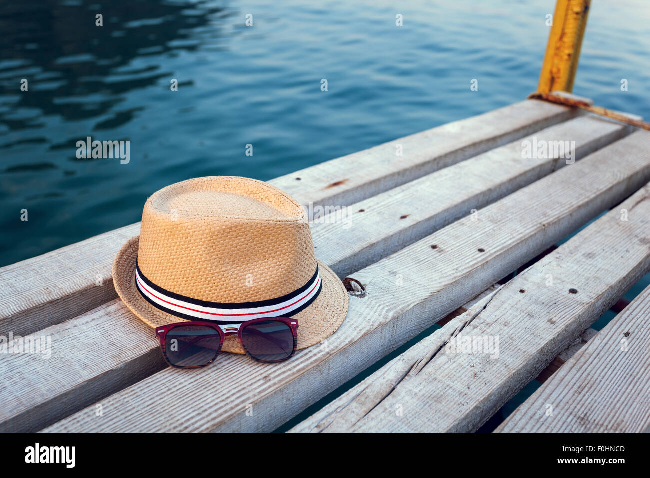 Lunettes de soleil, des tongs et un chapeau sur la texture en bois en été. Banque D'Images