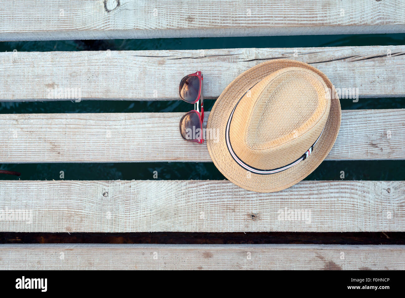 Lunettes de soleil, des tongs et un chapeau sur la texture en bois en été. Banque D'Images