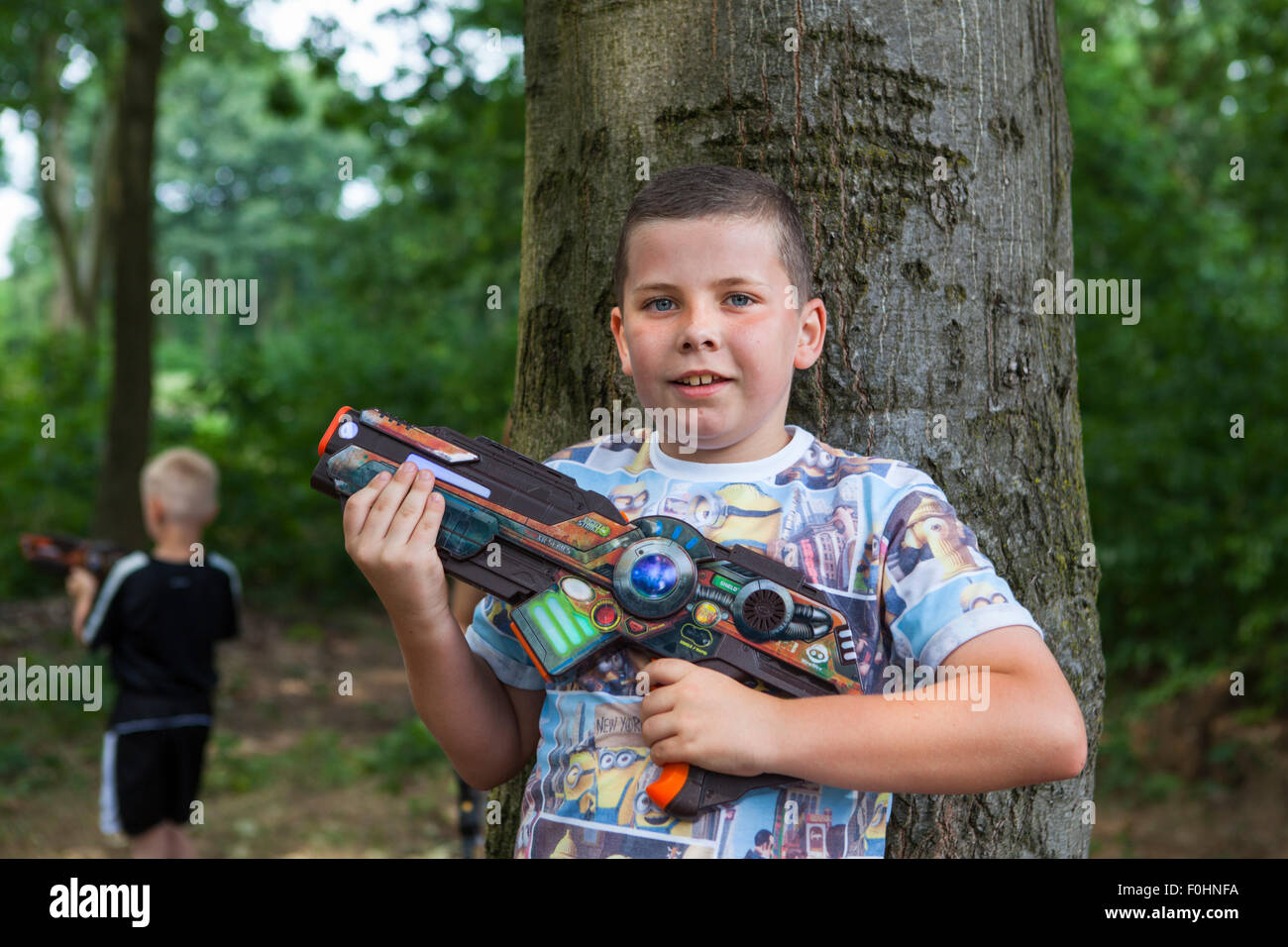Les garçons à poser et jouer un jeu de guerre avec des pistolets laser grève outdoor Banque D'Images