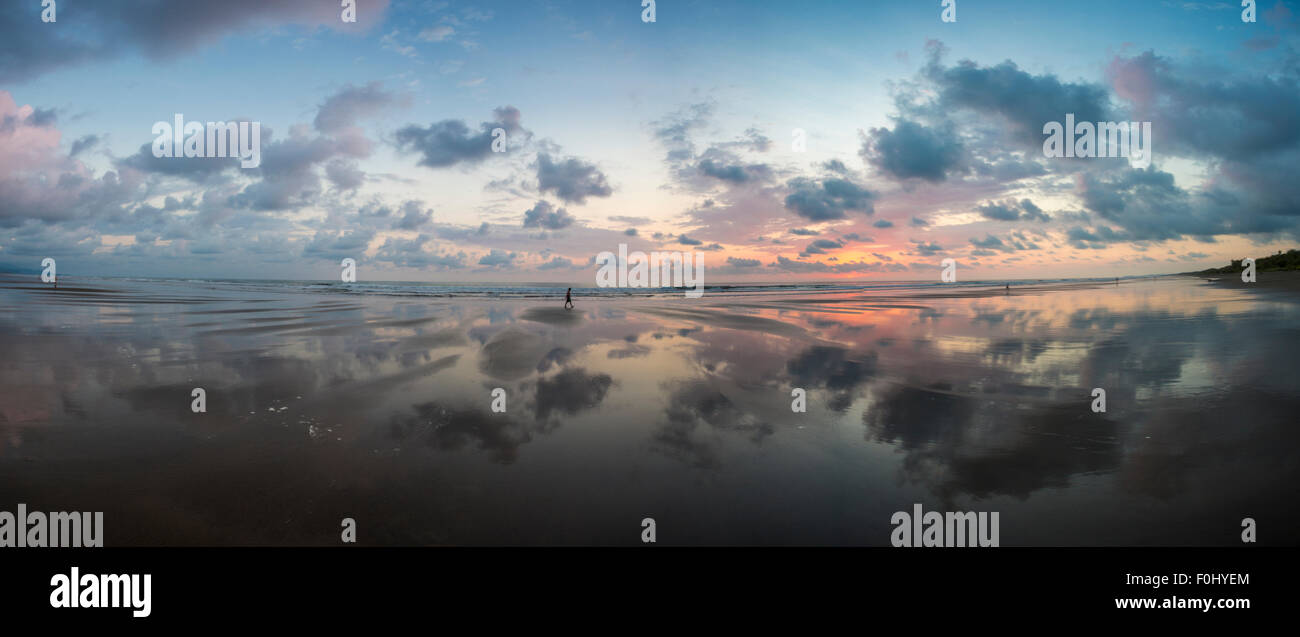 Vue du coucher de soleil sur la plage de Matapalo avec silhouette de personnes ayant une marche, le Costa Rica. Banque D'Images
