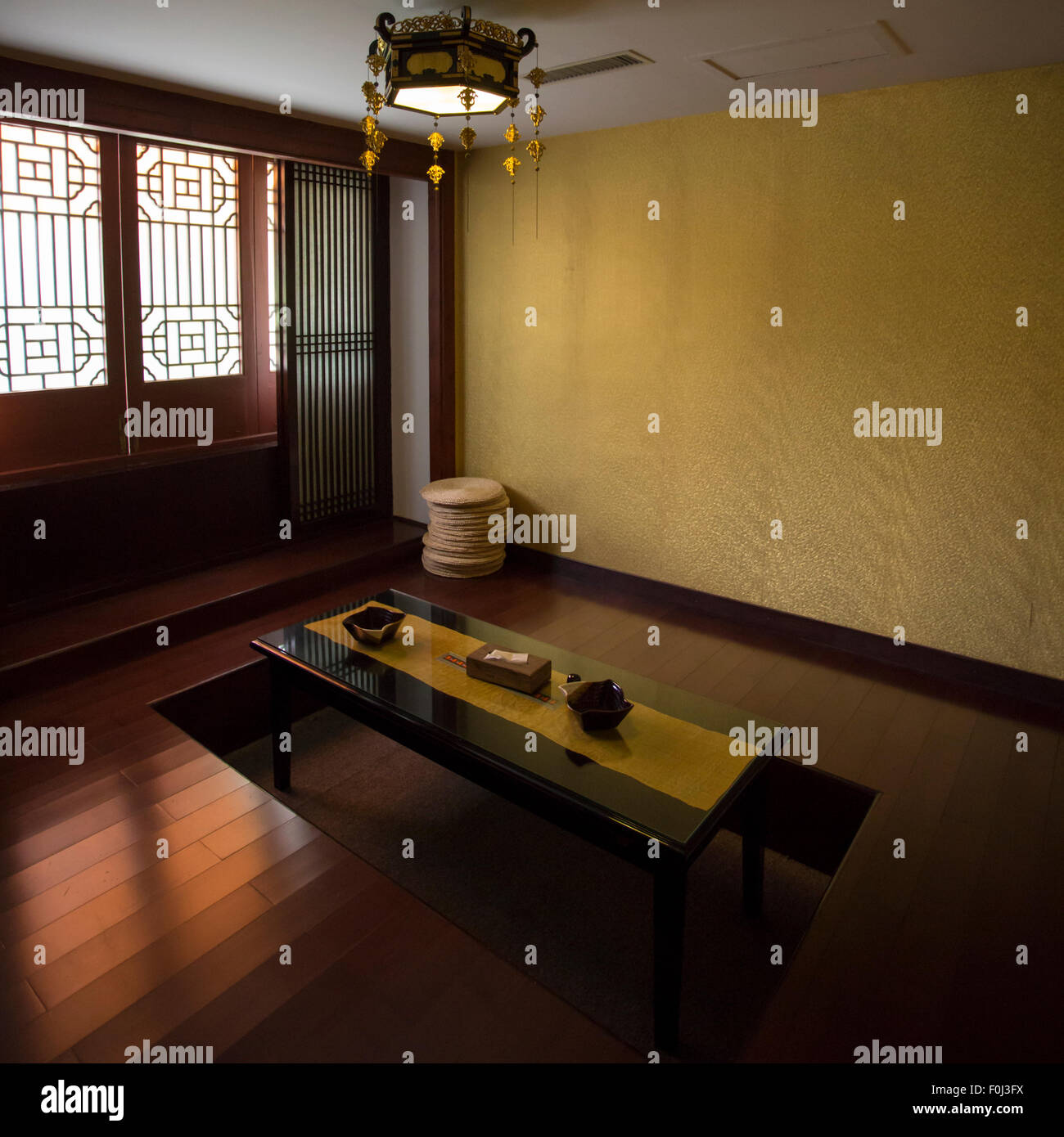 Décoration d'intérieur chinois avec un minimum tel qu'une table basse en bois et un tapis noir dans maison traditionnelle à Hangzhou, Chine. Banque D'Images