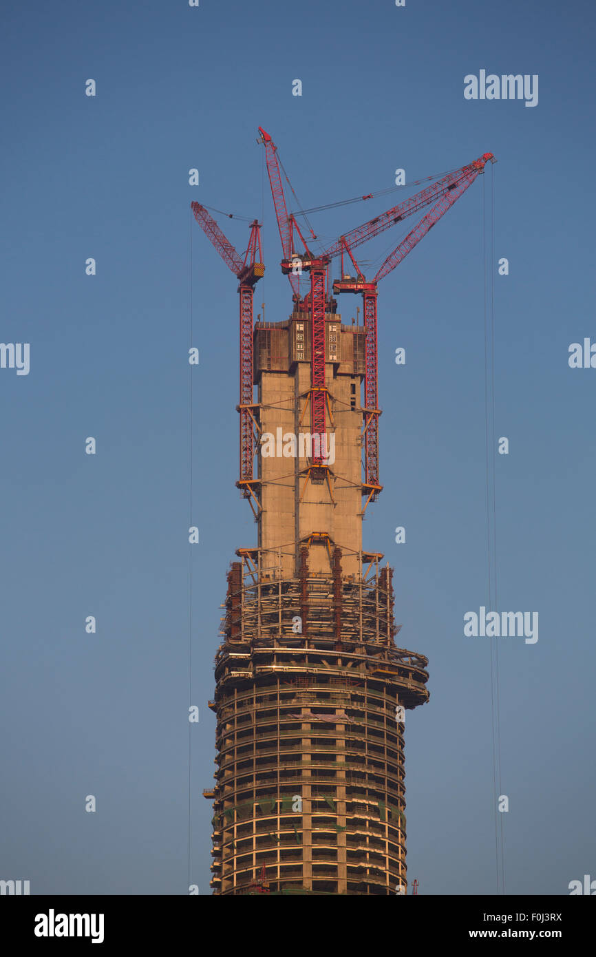 Gratte-ciel en construction à Shanghai contre un ciel bleu et une lumière orange. Banque D'Images