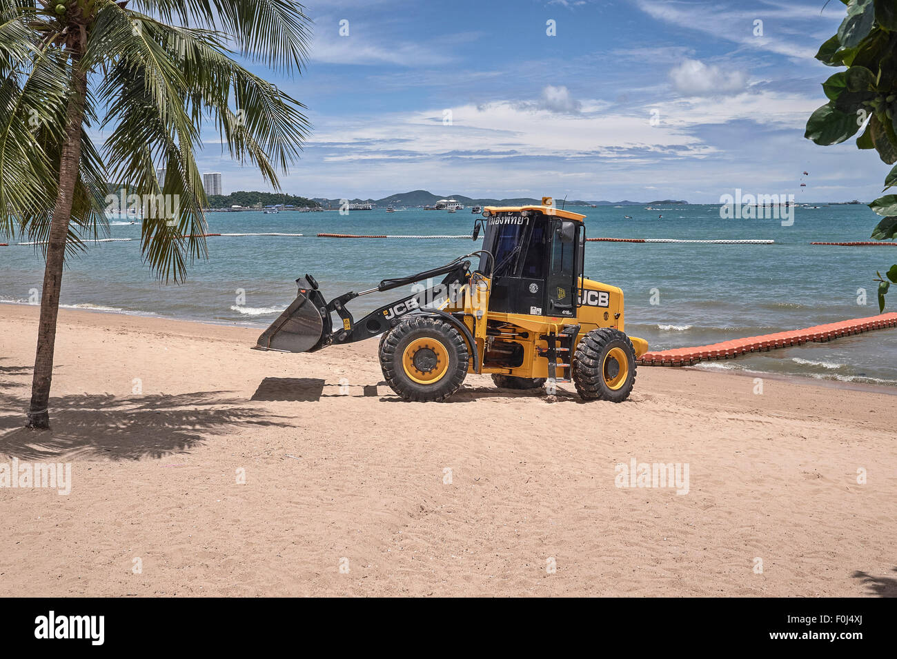 Digger tracteur au travail le nettoyage de la plage. S. E. Asia Pattaya Thaïlande Banque D'Images