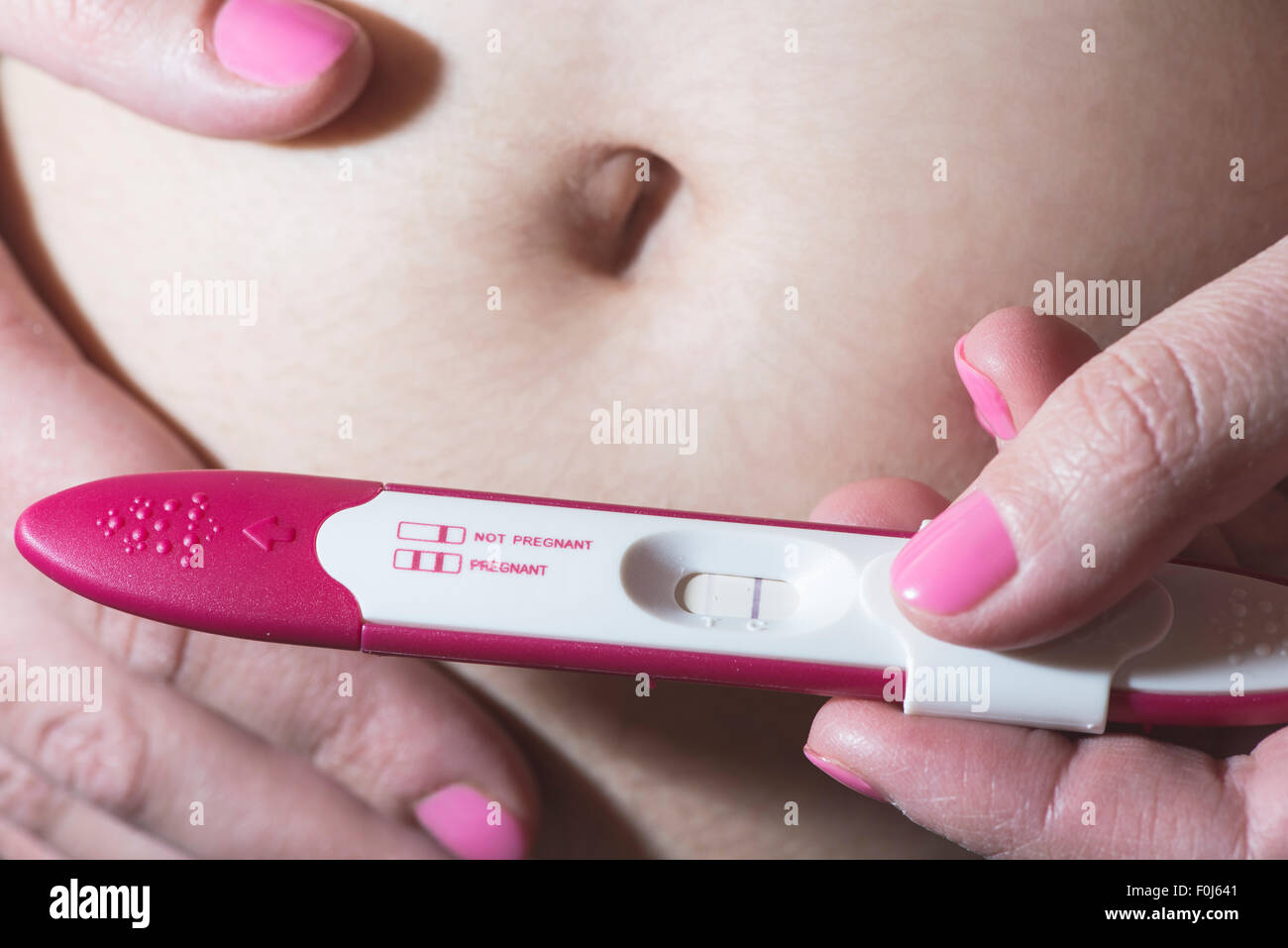 Pregnant woman holding un test de grossesse. Close up Banque D'Images