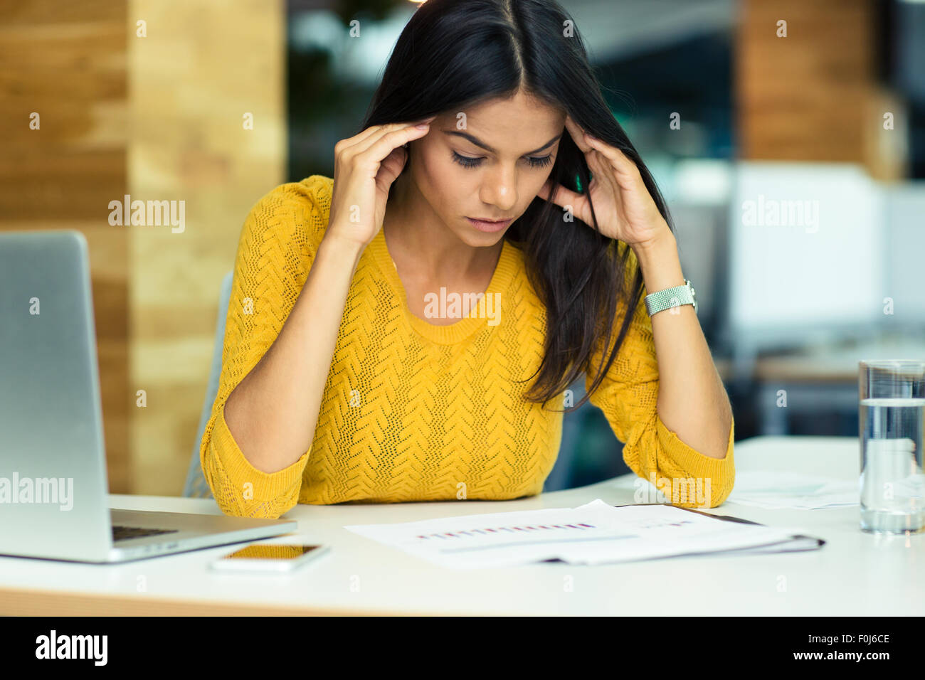 Portrait of a young casual businesswoman reading in office Banque D'Images