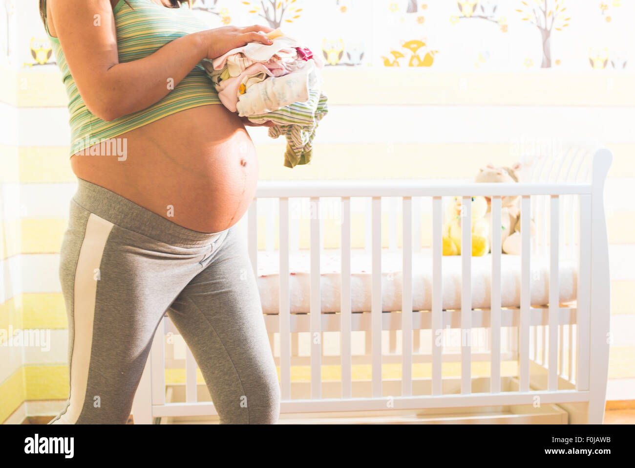 Les femmes enceintes dans une chambre de bébé. La préparation de la salle pour le bébé Banque D'Images