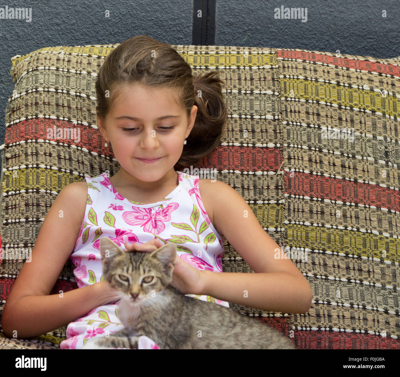 Petite fille et son chat mignon sitting on sofa Banque D'Images