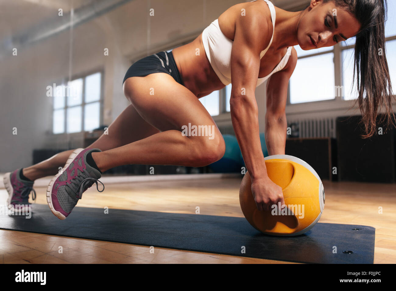Femme musculaire intense faisant de l'exercice dans la salle de sport de  base. Des femmes faisant de l'exercice de base sur Tapis de fitness avec  kettlebell dans les clu Photo Stock -