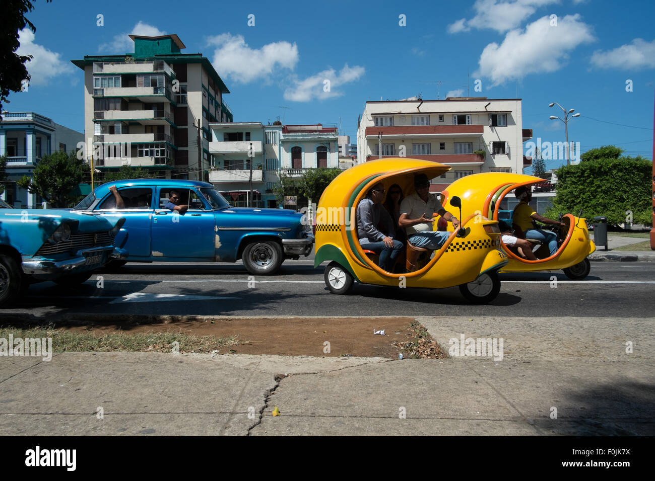 Coco-taxis et voitures classique des années 50 dans les rues de La Havane, Cuba Banque D'Images