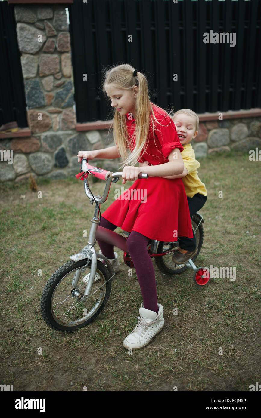 Les enfants voyagent en vélo dans une cour Banque D'Images