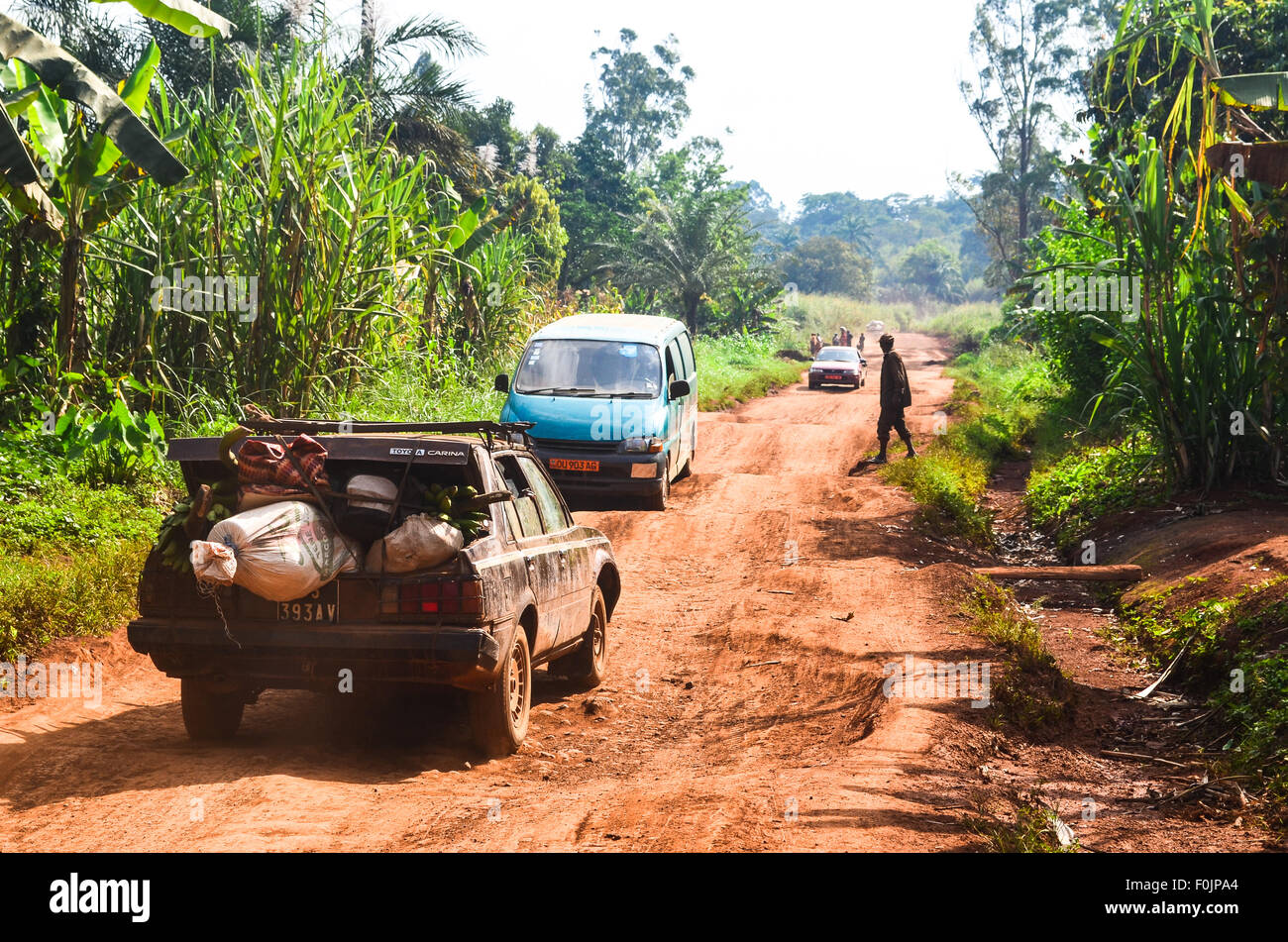 Les taxis locaux sur une terre rouge route de terre en milieu rural en Afrique Banque D'Images