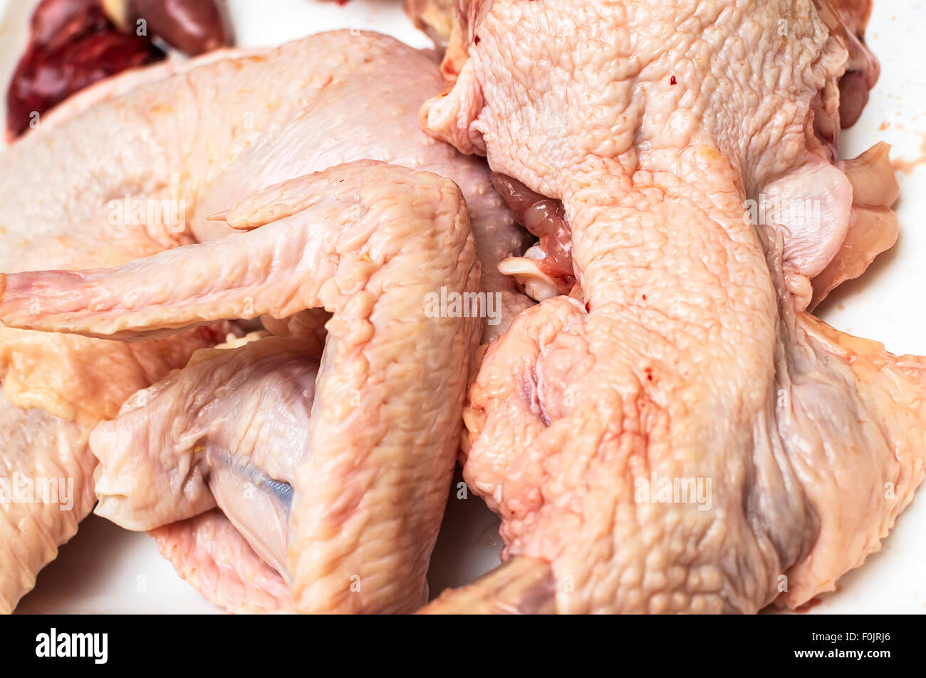Ailes de poulet crues sur fond blanc. Focus sélectif. Banque D'Images