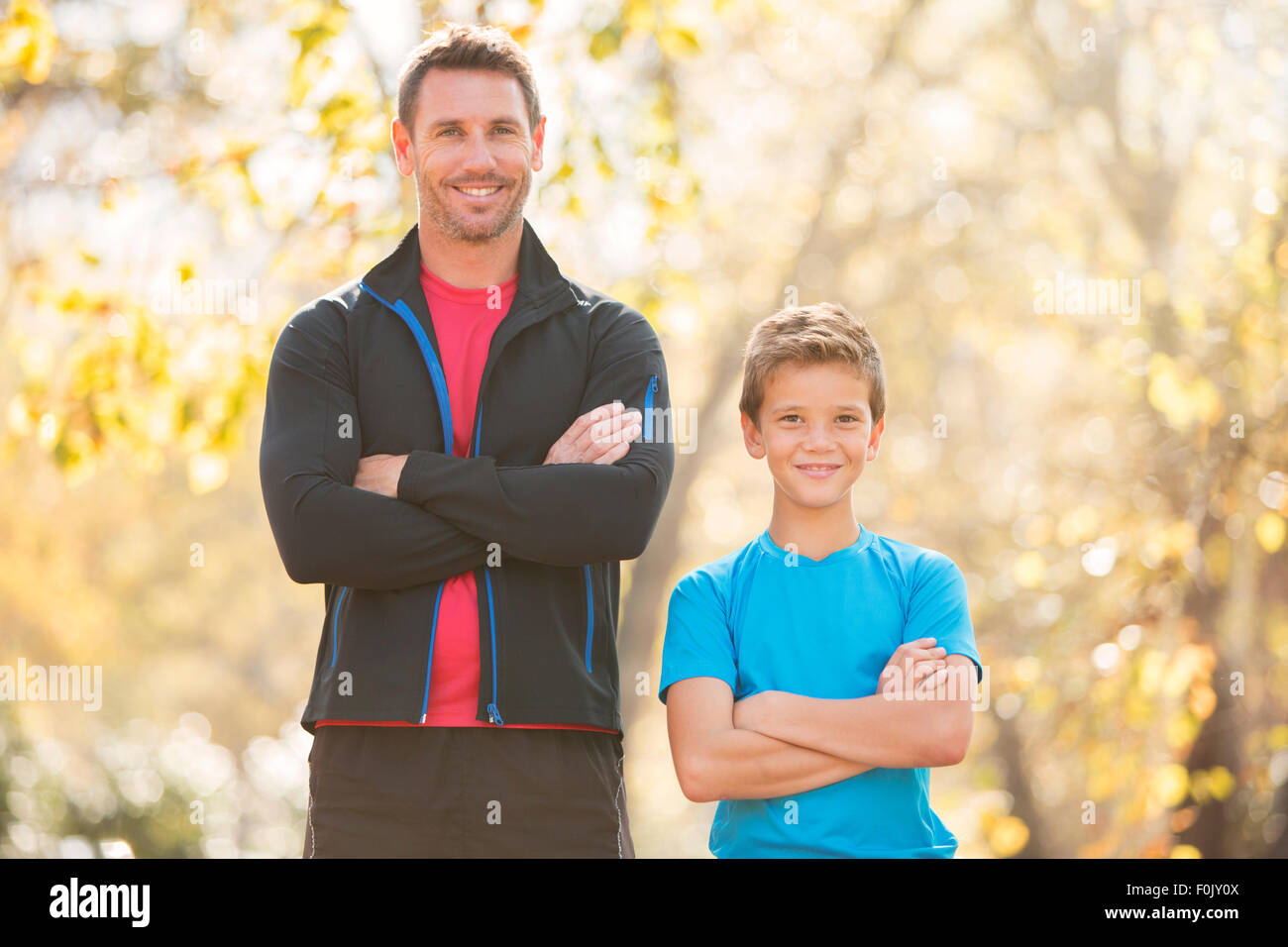 Portrait confiant père et fils avec les bras croisés en plein air Banque D'Images
