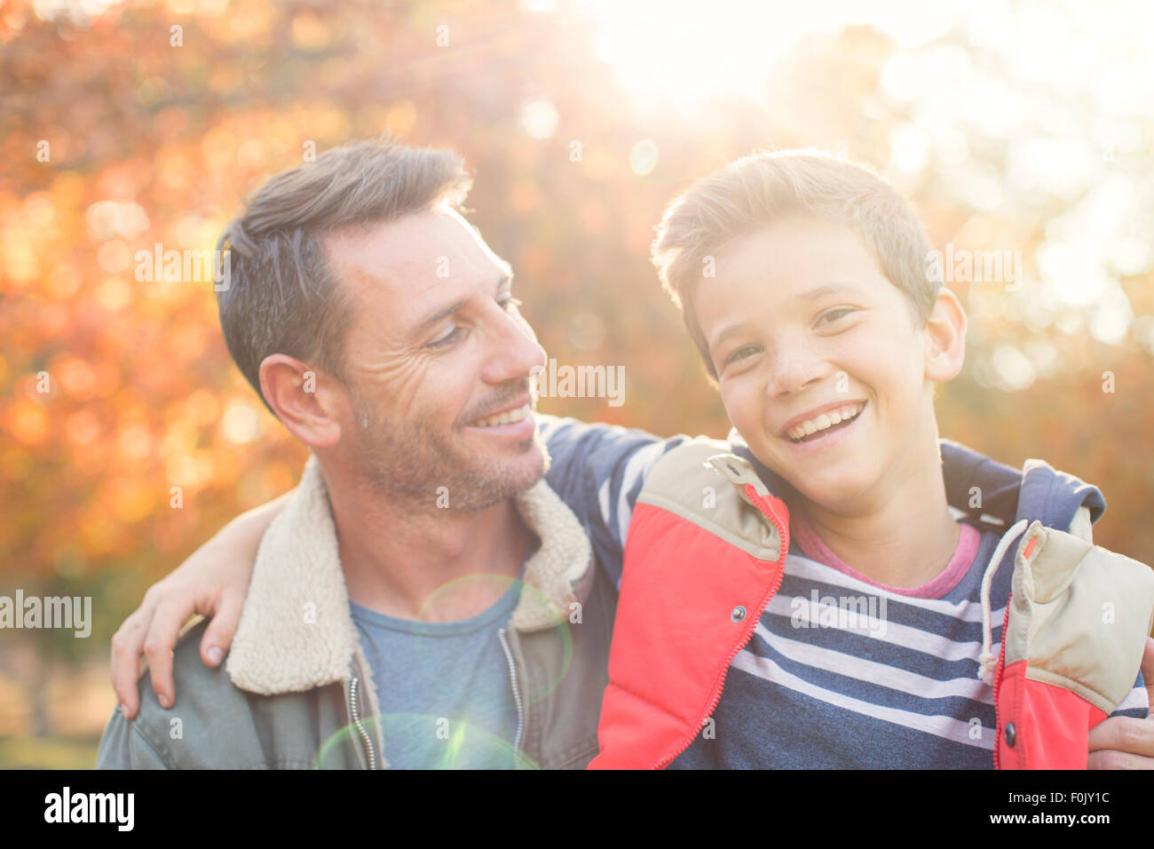 Portrait of smiling père et fils en face de feuilles d'automne Banque D'Images