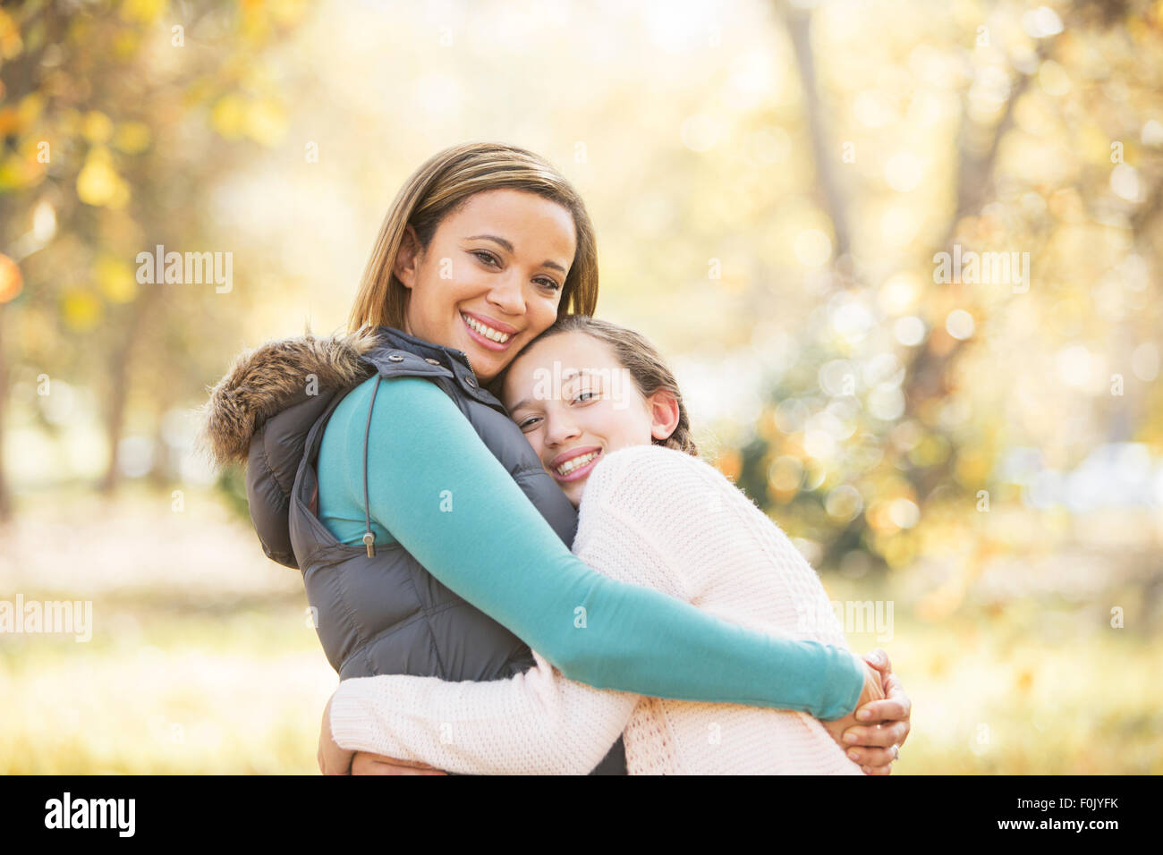 Portrait of smiling mother and daughter hugging outdoors Banque D'Images