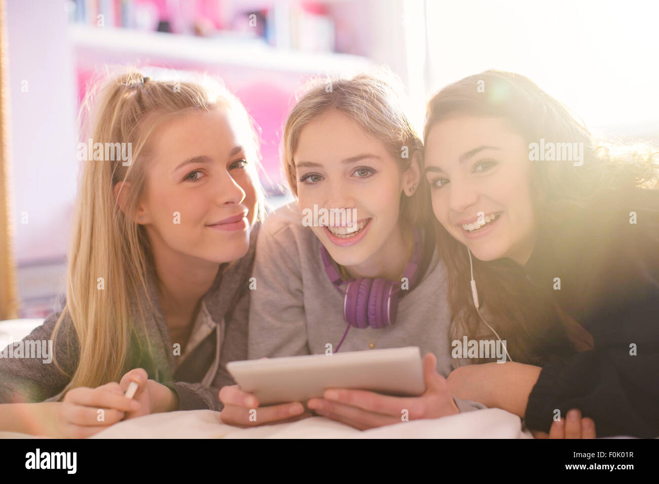 Portrait of smiling teenage girls using digital tablet Banque D'Images