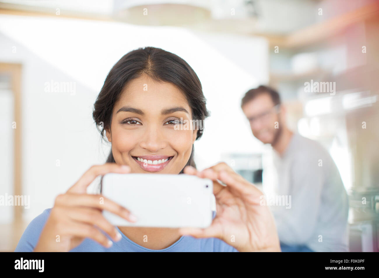 Portrait smiling woman using camera phone Banque D'Images