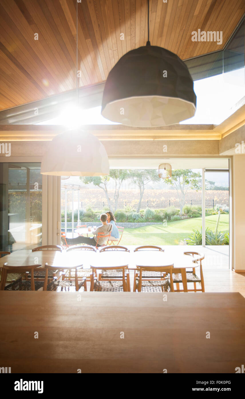 Couple sitting on sunny patio de luxe Banque D'Images