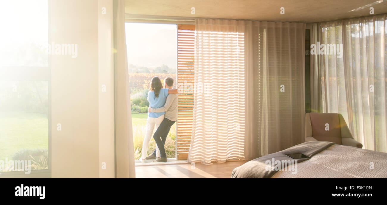 Couple hugging at porte patio dans la chambre Banque D'Images