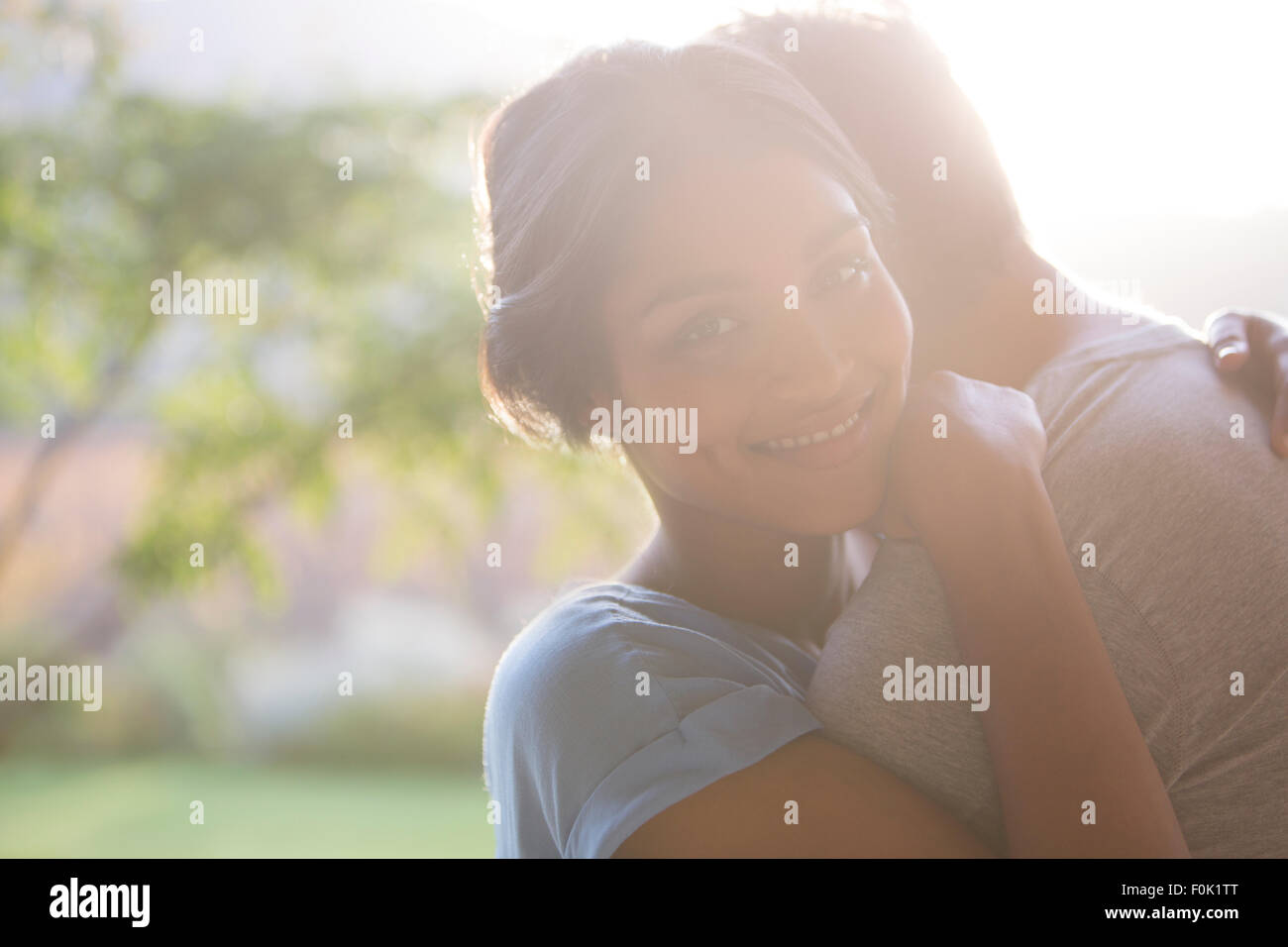 Portrait of smiling woman hugging man outdoors Banque D'Images