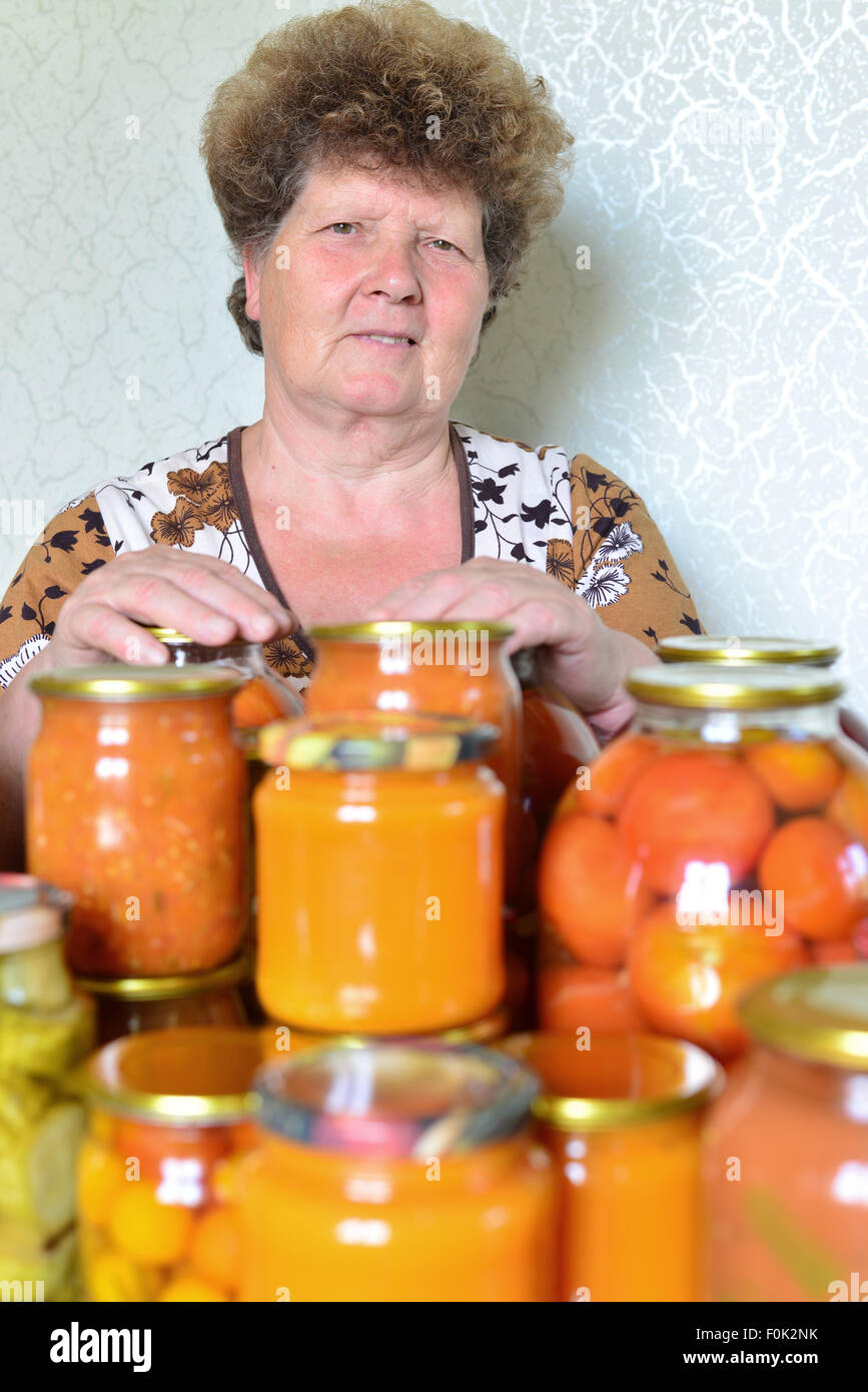 Femme au foyer mature avec des légumes en conserve maison Banque D'Images