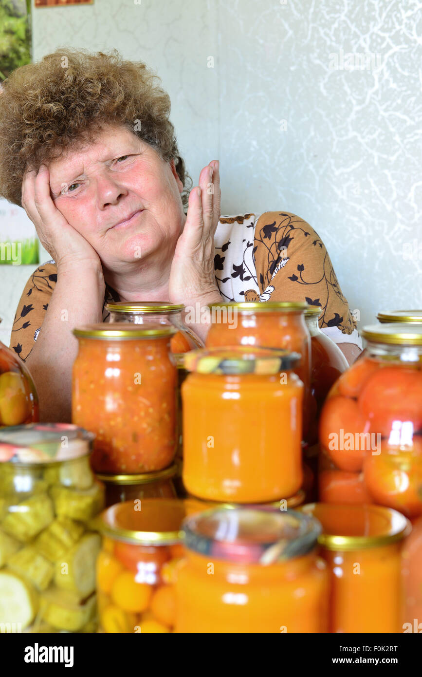 Femme au foyer mature avec des légumes en conserve maison Banque D'Images