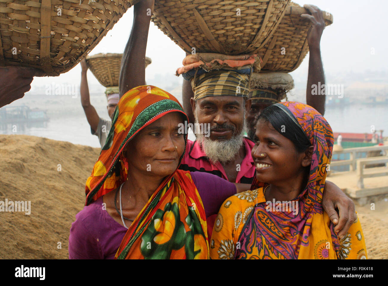Portrait de femme au Bangladesh du travail. Ils sont porte de lourdes charges de sable en équilibre sur leurs têtes dans la banque de fleuve Turag. Banque D'Images