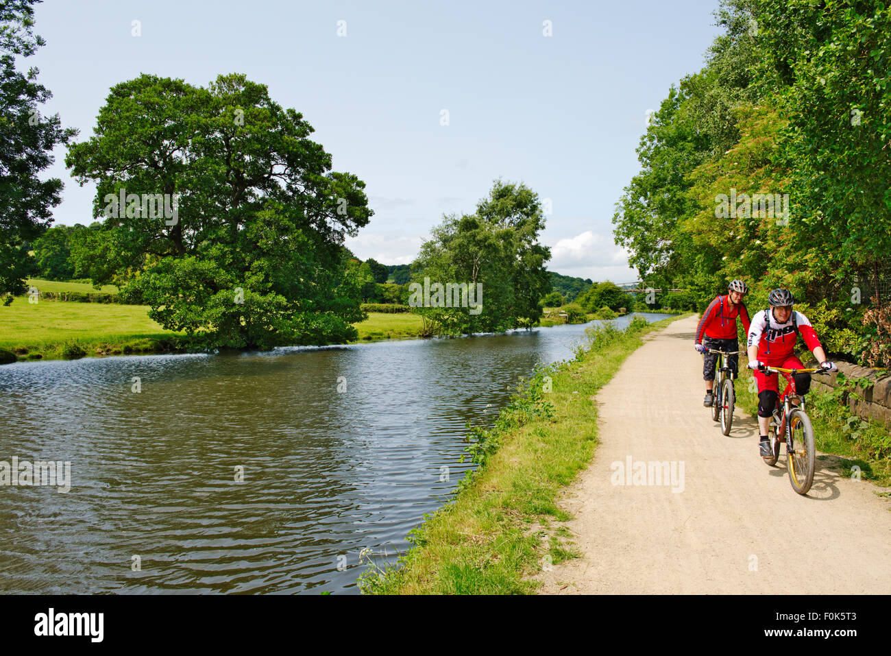 Randonnée à vélo le long du canal de Leeds et Liverpool chemin de halage aux beaux jours de l'été, près de Calverley Bridge, West Yorkshire Banque D'Images
