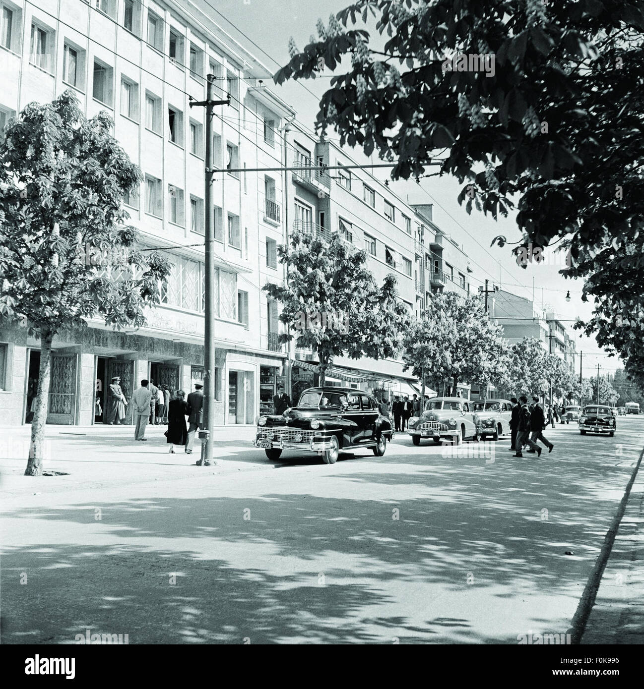 Atatürk Boulevard dans les années 1950, avec le Grand Movie Theater et un bloc de bureaux visibles. Cette scène reflète le développement urbain et le style architectural de la Turquie du milieu du XXe siècle. Banque D'Images Atatürk Boulevard dans les années 1950, avec le Grand Movie Theater et un bloc de bureaux visibles. Cette scène reflète le développement urbain et le style architectural de la Turquie du milieu du XXe siècle. Banque D'Images