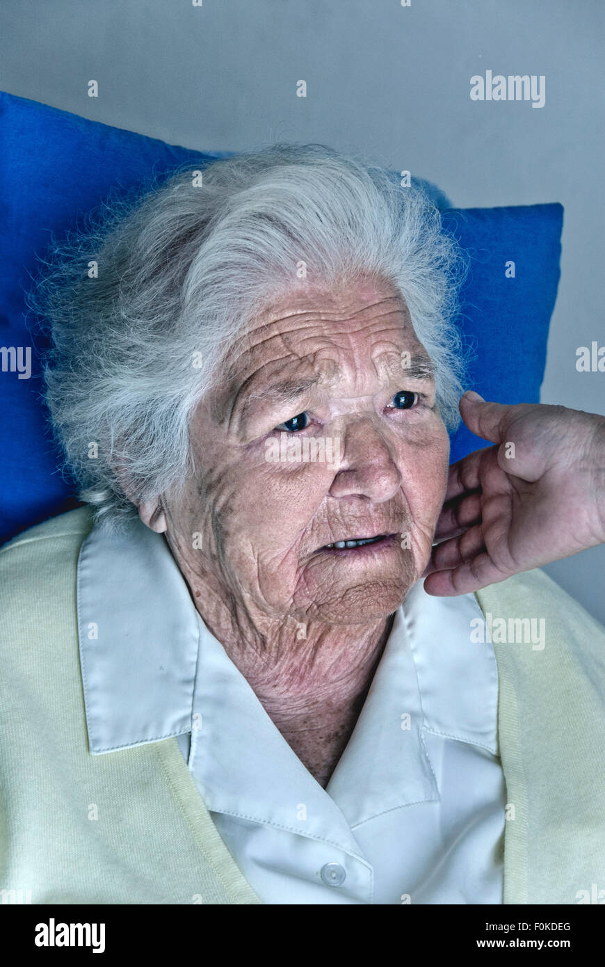 Douleur de confort se plaignant appréhensive femme âgée préoccupée avec la main réconfortante de soignant touchant sa joue Banque D'Images
