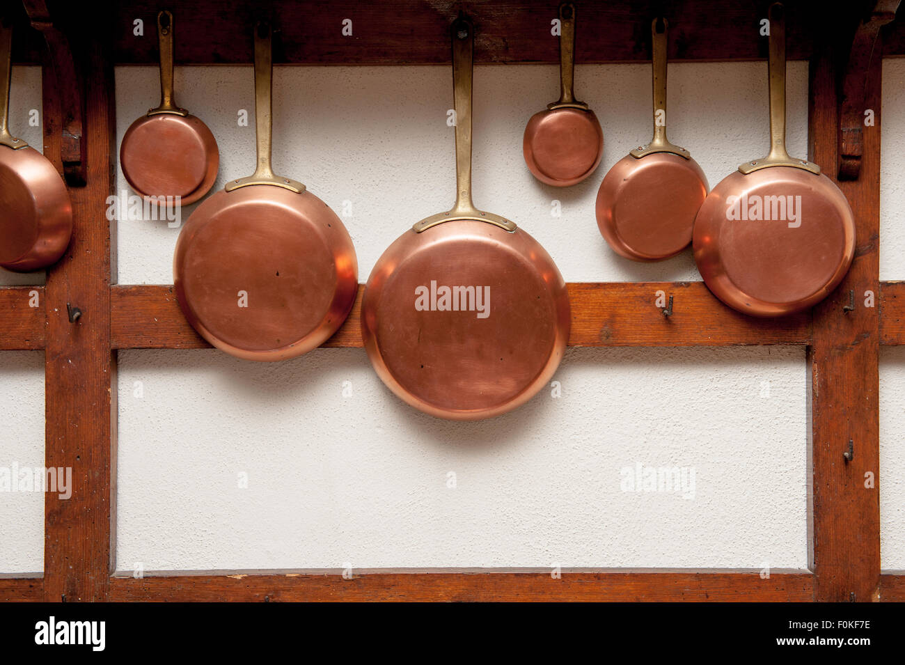 Rangée de vintage en cuir, de taille différente, pendu sur planche en bois dans la cuisine, cadre vertical Banque D'Images