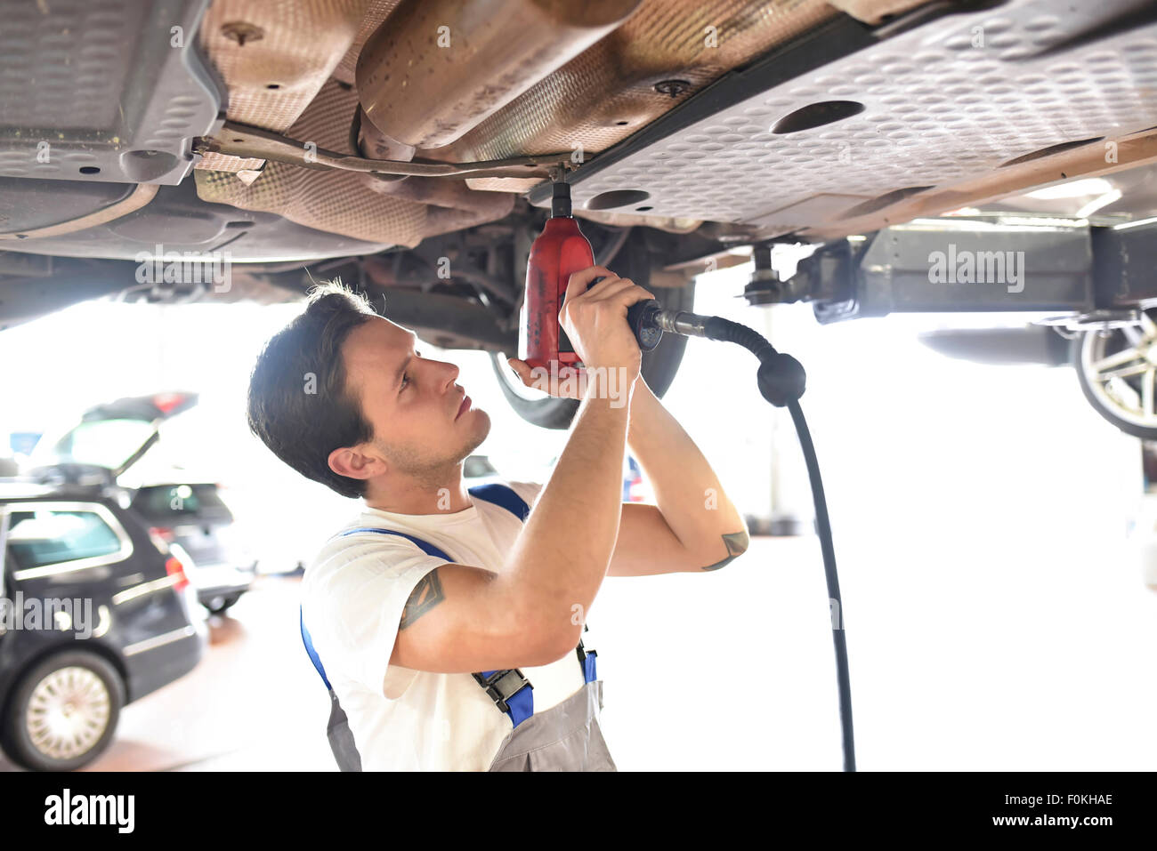 Mechanic repairing pont d'une voiture dans un garage Banque D'Images