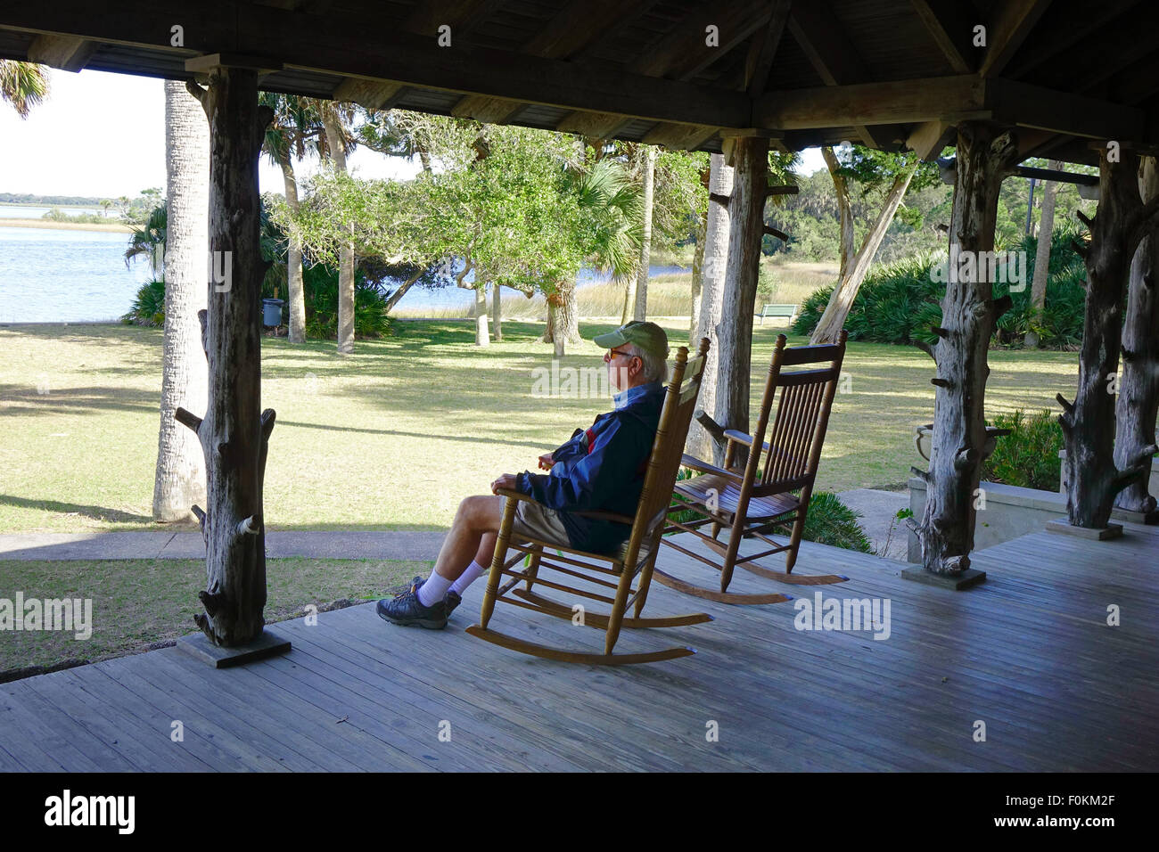 L'homme dans une chaise à bascule sur le porche de la loge à Princess Place Préserver, Flagler county Florida Banque D'Images