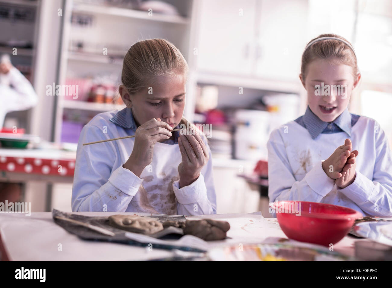 Deux jeunes filles qui travaillent sur la modélisation de l'argile dans la classe d'art à l'école Banque D'Images