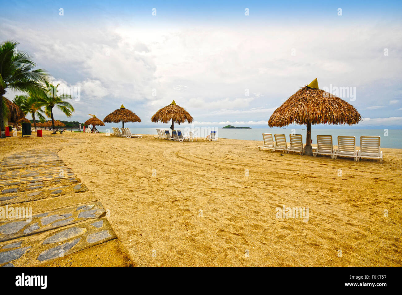 Scène de plage à un resort tropical montrant des huttes et pathway Banque D'Images