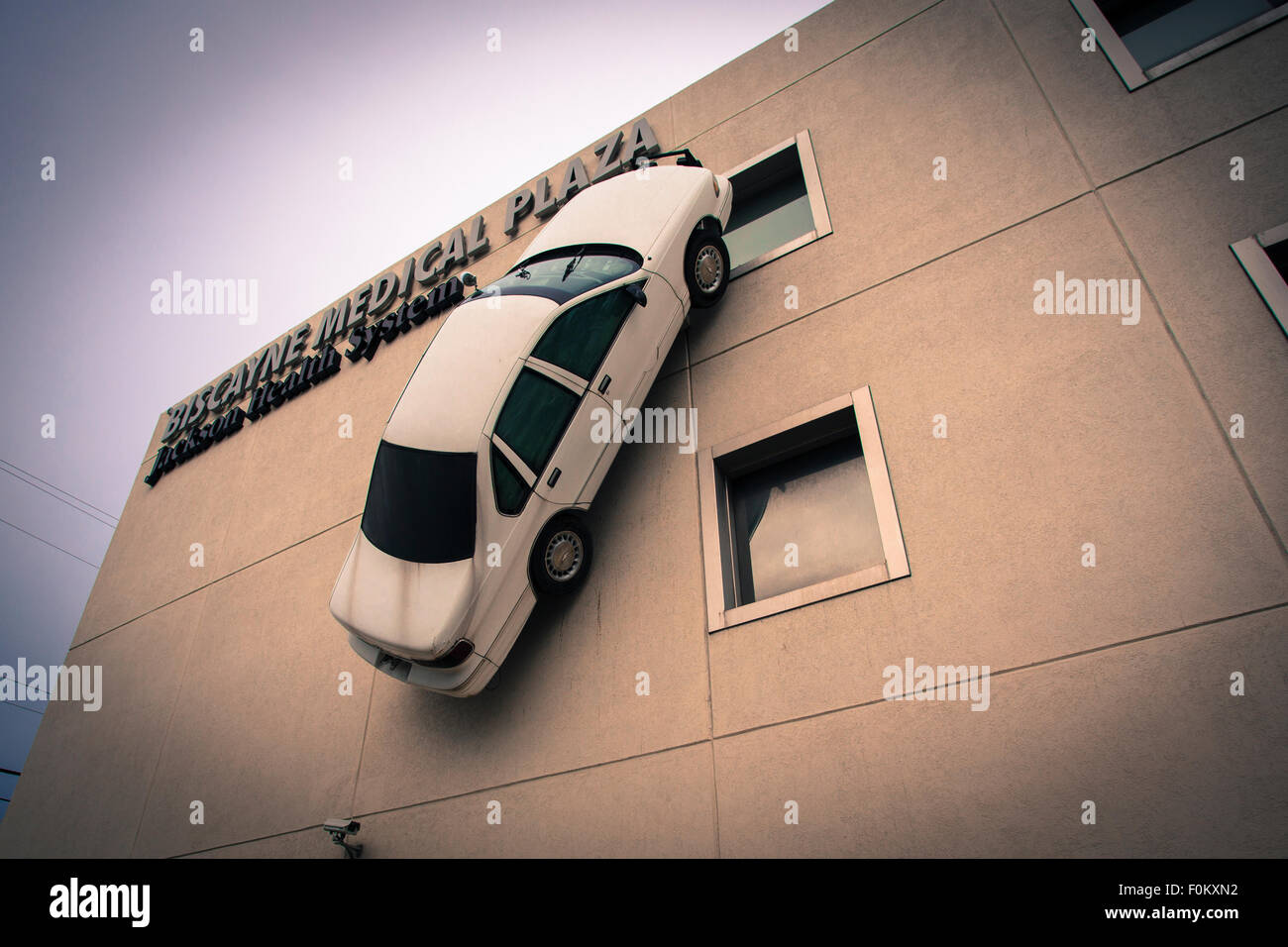 L'installation d'art dans la ville de du Biscayne Medical Plaza. Une voiture blanche est collée à la verticale sur la façade. Banque D'Images
