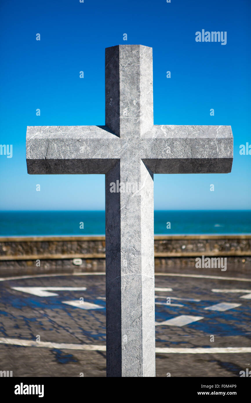 Ciel bleu, l'Atlatic océan et la croix de pierre en mémoire de marins décédés. Lekeitio, Basque Banque D'Images