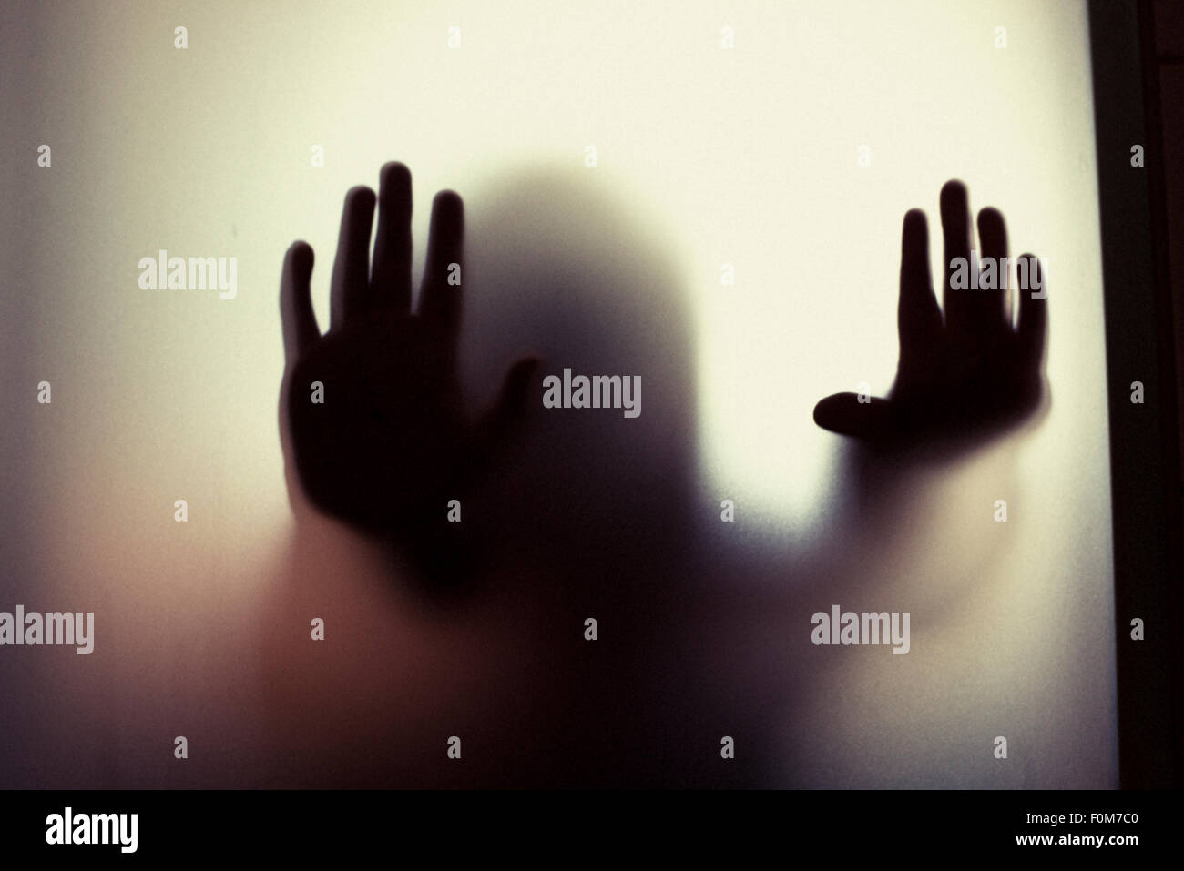 Silhouette de petit enfant qui fait mains. Image conceptuelle des craintes de la petite enfance, l'abus et la sécurité des enfants. Banque D'Images