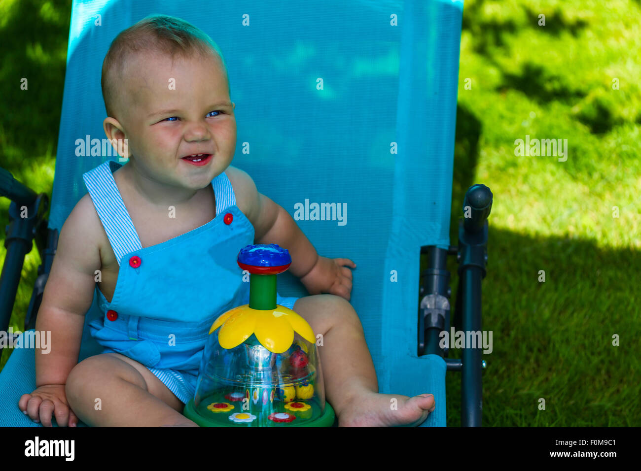 Charmant caucasian baby boy sur chaise longue dans park Banque D'Images