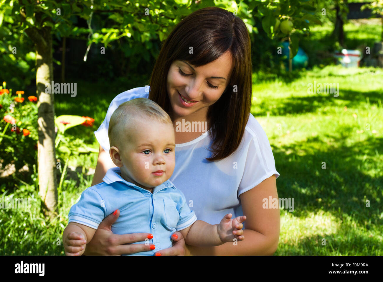 Charmant caucasian baby boy with mother in garden Banque D'Images