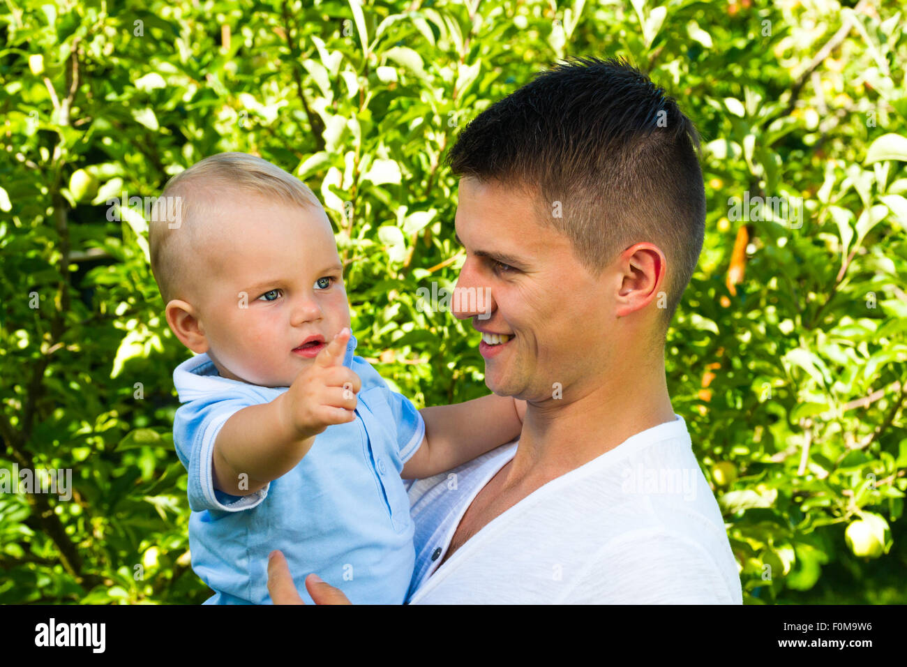 Charmant caucasian baby boy avec le père dans le jardin Banque D'Images