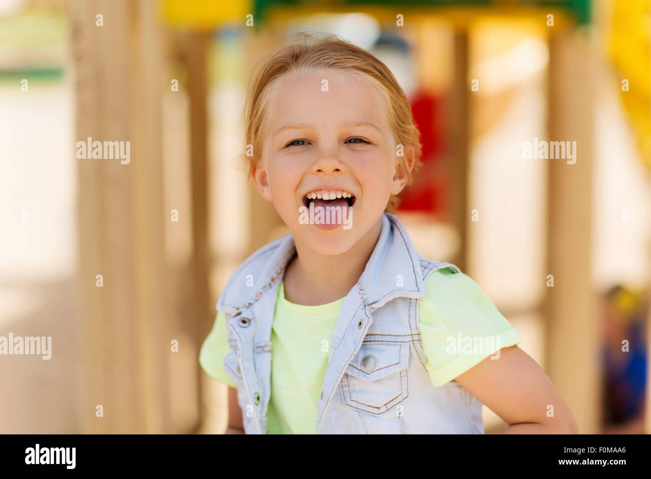 Happy little girl montrant langue sur aire Banque D'Images