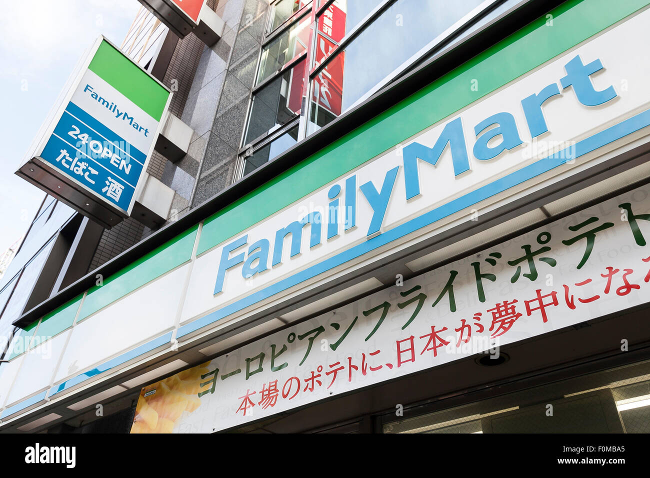 Sur les enseignes, FamilyMart affichage à l'entrée de son magasin de proximité le 18 août 2015, Tokyo, Japon. FamilyMart qui est la troisième plus grande chaîne de dépanneurs devrait annoncer qu'elle ferait l'acquisition d'un petit opérateur basé sur Nagoya ''Cocostore Corp.'' et ses 657 magasins. FamilyMart devrait également intégrer les opérations avec UNY Group Holdings Co., qui exploite le quatrième plus grande chaîne Circle K Sunkus Co., en septembre 2016. Ce serait voir le nouveau groupe courir environ 18 400 magasins au Japon, 500 de plus que le plus grand rival Seven-Eleven. (Photo de Rodrigo R Banque D'Images