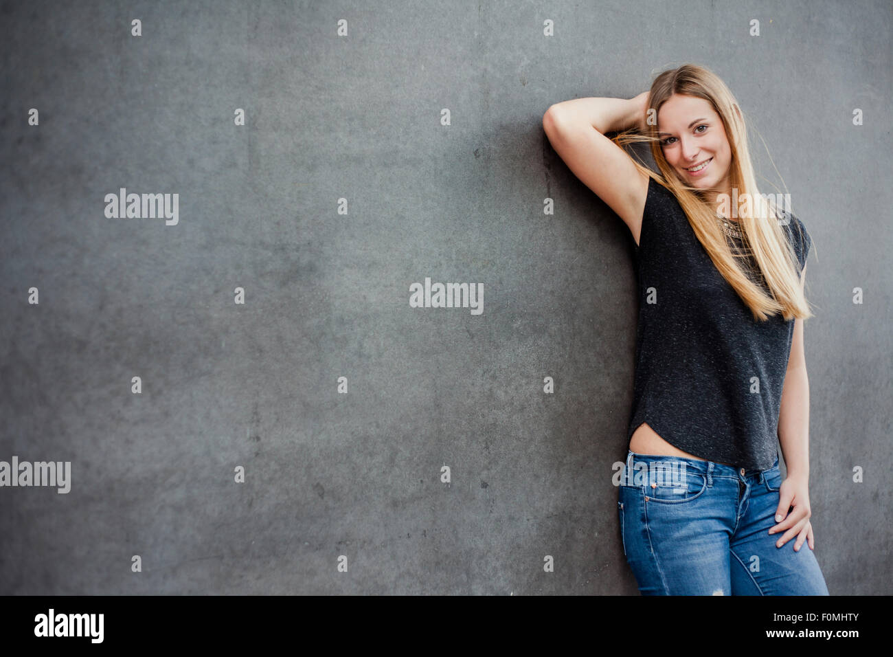 Belle adolescente en face de mur de béton Banque D'Images