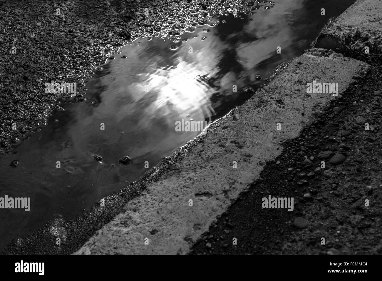 La réflexion du soleil dans une flaque d'eau après une tempête de pluie Banque D'Images