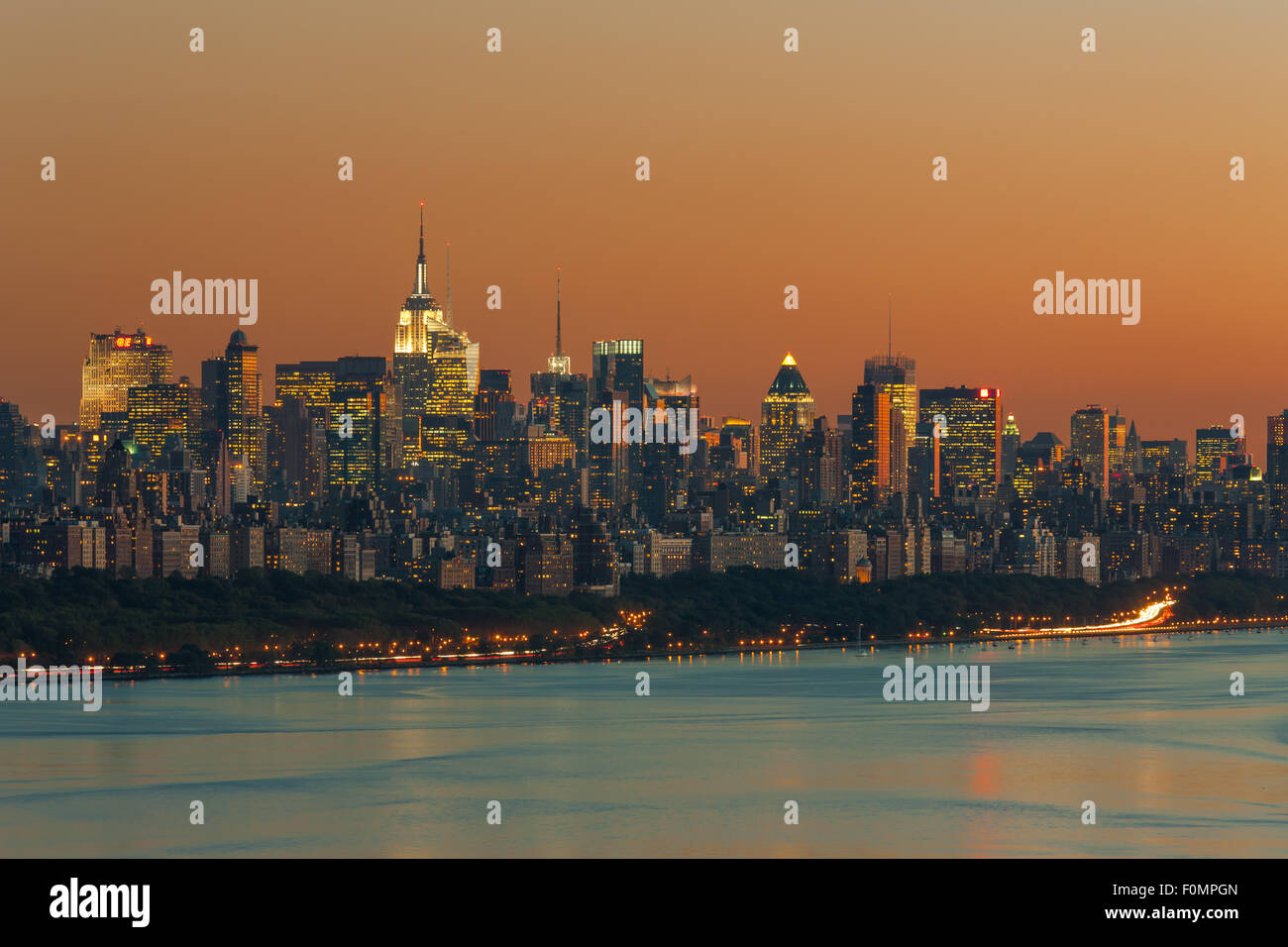 Le ciel est orange sur les toits de Manhattan et l'Hudson juste après le coucher du soleil à New York. Banque D'Images