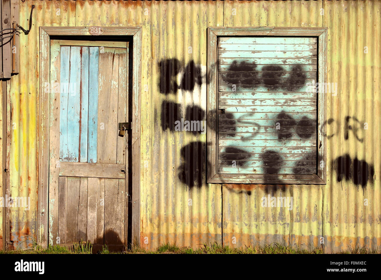 Porte fermée avec un casier sur la vieille usine avec un graffiti à Punta Arenas, Chili. Banque D'Images