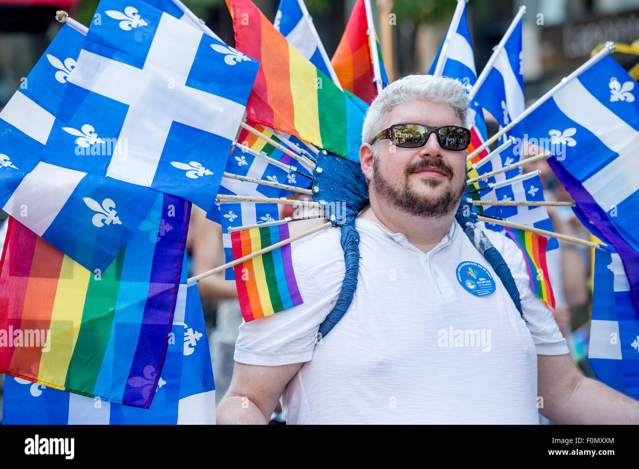 Montréal, Canada, 16 août 2015. Un participant est gay et gay Québec transportant de nombreux drapeaux arc-en-ciel à la Gay Pride Parade 2015 à Montréal. © Marc Bruxelles/Alamy Live News Banque D'Images
